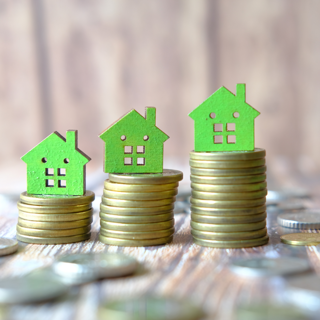 Drie groene huisjes op geld